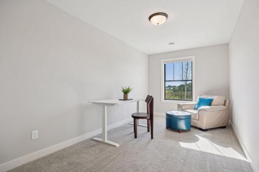 This lower-level bedroom is currently styled as a versatile bonus space or home office, offering quiet privacy and flexible functionality to suit your needs