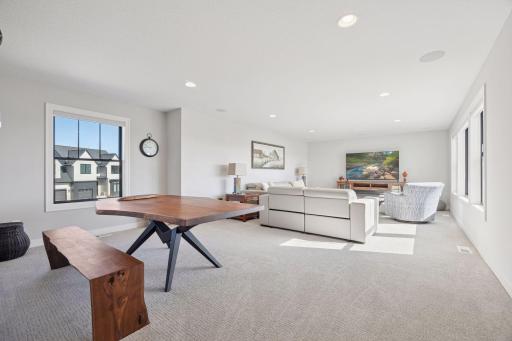This spacious bonus room or additional family room on the upper level is filled with natural light from windows on two sides