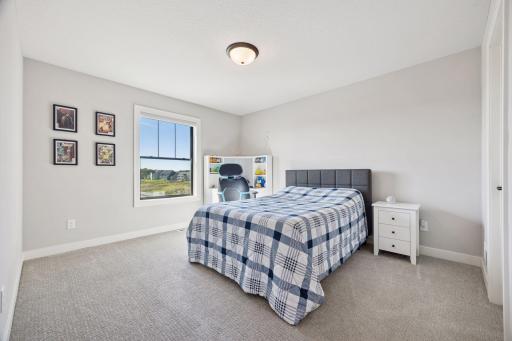 This upper-level bedroom offers tranquil views and plenty of space for a desk