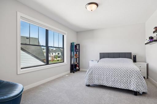 Another inviting upper-level bedroom features a generously sized window that fills the space with natural light