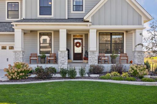 A spacious front porch and elegant landscaping create a warm, welcoming entrance
