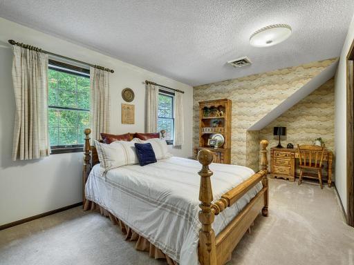 3rd bedroom on upper level with desk area and spacious closet.