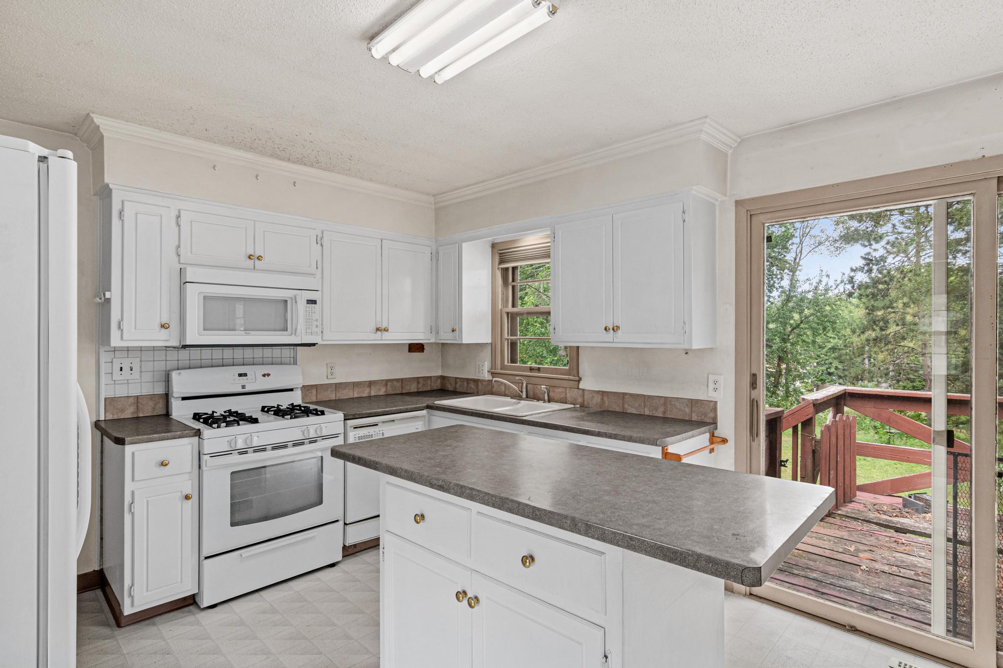 Kitchen with center island, gas stove, dishwasher, and walk out to backyard!