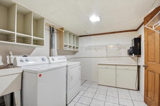Nice size laundry room with folding table & work sink.