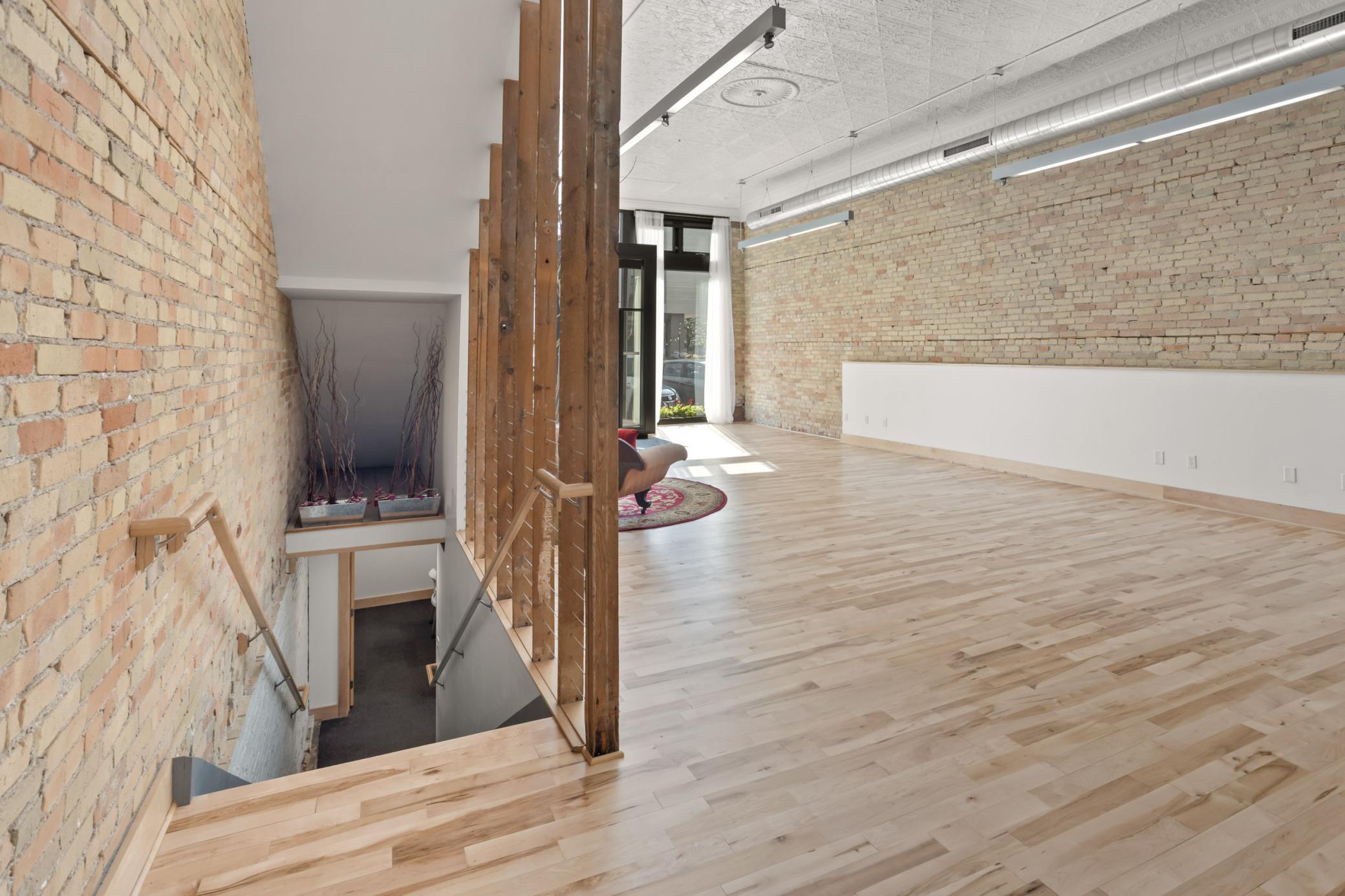 Main floor space, looking toward front entrance, stairwell to basement