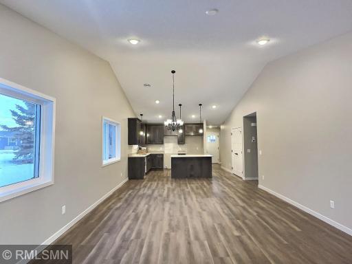 The open design features a wide open space from the kitchen to the sunroom. The wall is lined with windows so natural sunlight and views of the outdoors enhances this area of the home. Photo is from model home.
