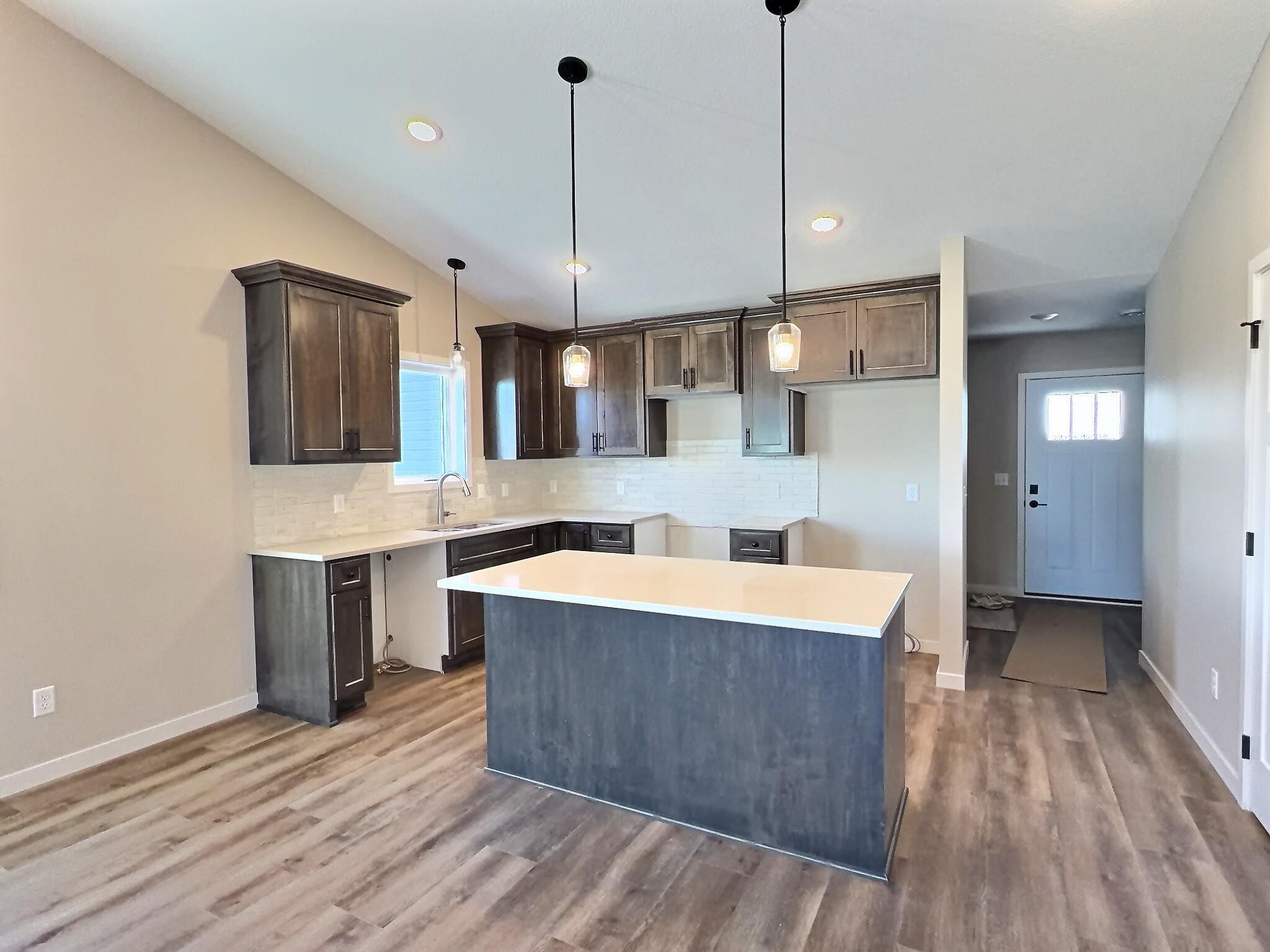 Kitchen includes quartz counter tops, walk in pantry and ample cabinets. Behind the kitchen is large closet and the laundry room.