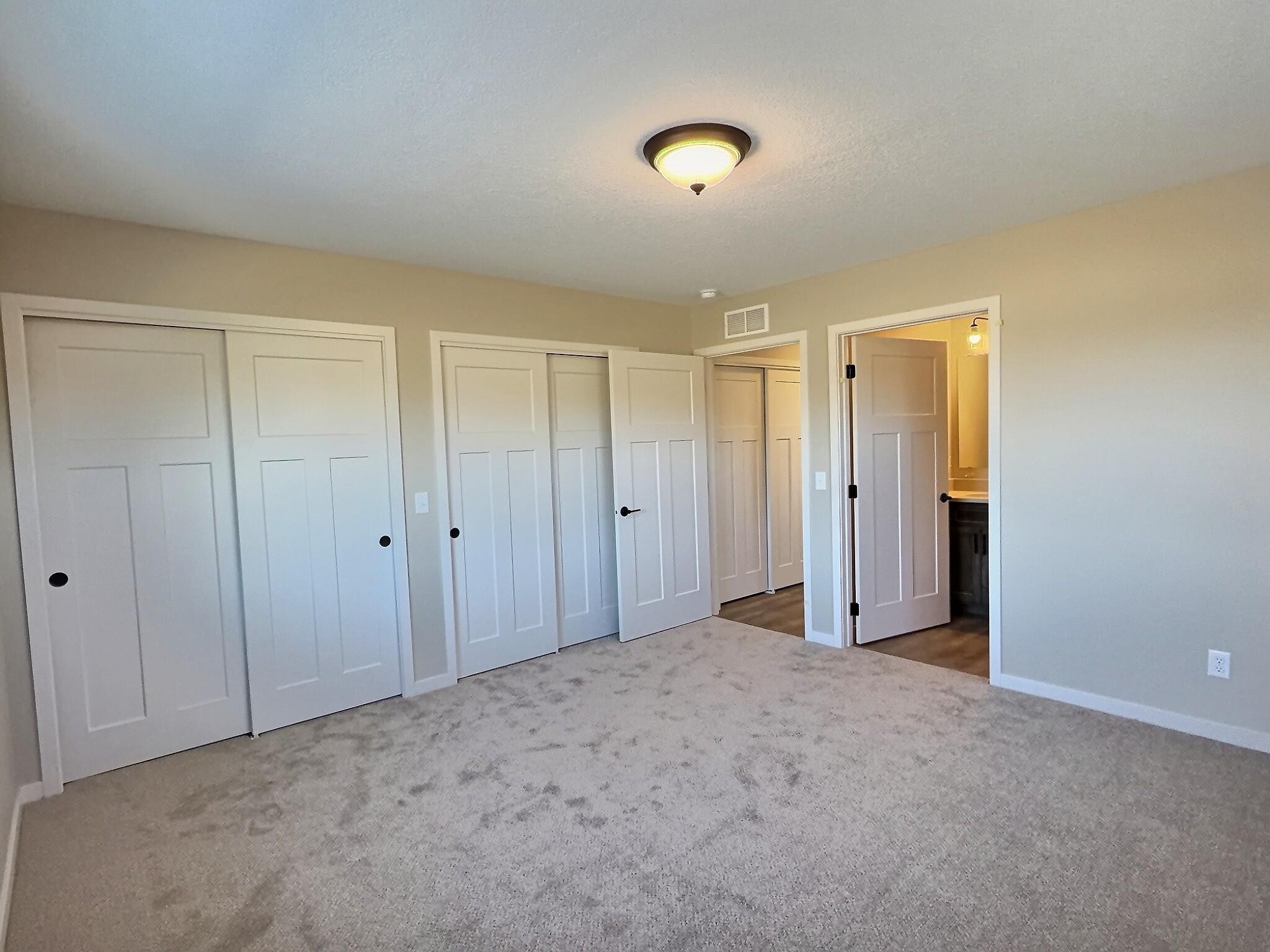 Primary bedroom includes dual closets and private bath with a walk in shower. Bedroom is located on the back side of the home.