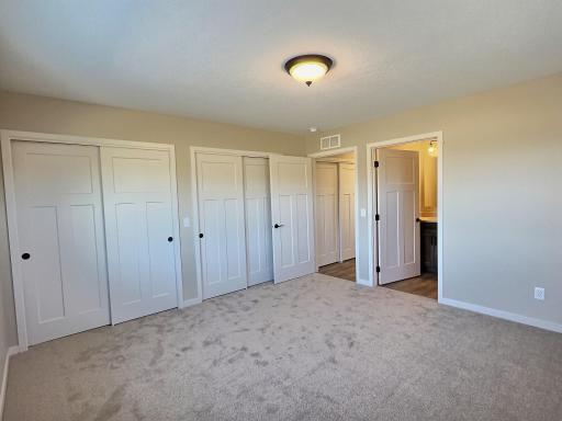 Primary bedroom includes dual closets and private bath with a walk in shower. Bedroom is located on the back side of the home.