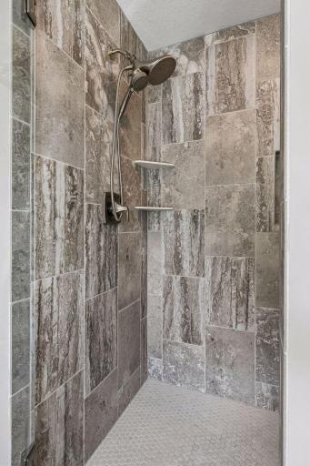 Beautiful, tiled shower in the primary suite.