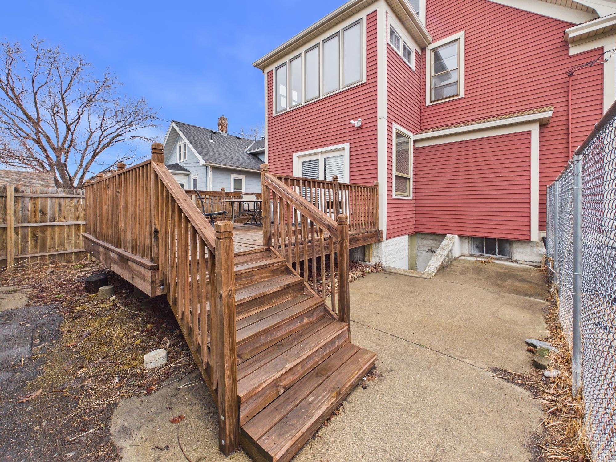 Deck and patio entrance to kitchen. Upper level sunroom windows above. - 3032 Longfellow Ave., Minneapolis