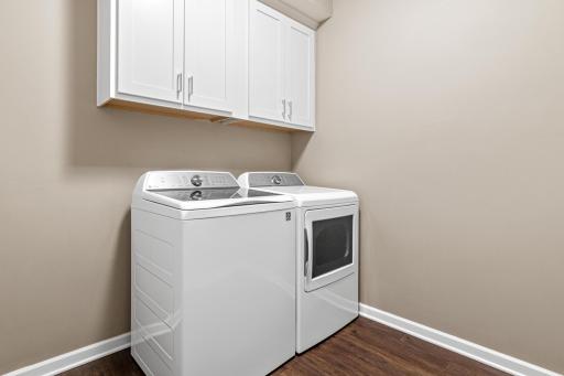 Convenient main-floor laundry located just inside the garage door. Features high-efficiency appliances and overhead cabinetry for storage. This functional transition space keeps the home organized and highlights the ease of one-level living.