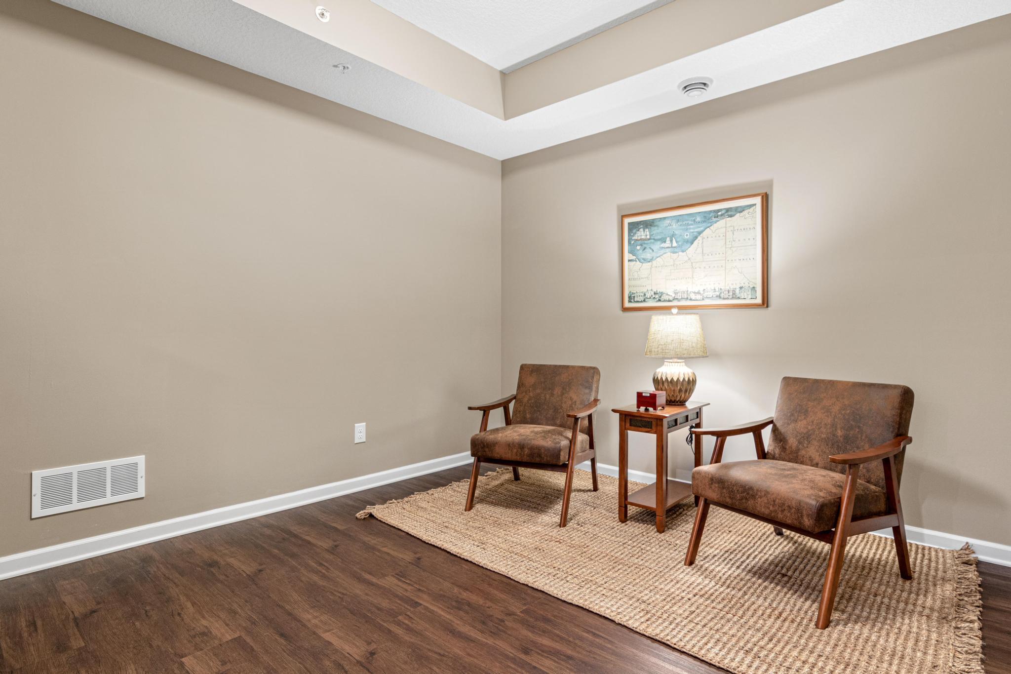 Main level flex room featuring beautiful flooring, recessed lighting, and a tray ceiling. This versatile, open-concept space is perfect for a home office, den, or reading nook. A bright and airy addition to one-level living!