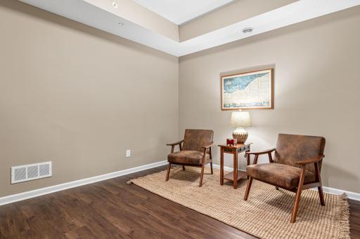 Main level flex room featuring beautiful flooring, recessed lighting, and a tray ceiling. This versatile, open-concept space is perfect for a home office, den, or reading nook. A bright and airy addition to one-level living!