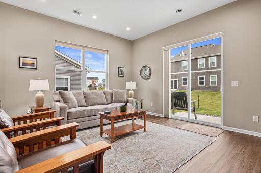 Open-concept main level featuring large windows for abundant natural light and a patio door providing seamless access to the private outdoor space and kitchen.