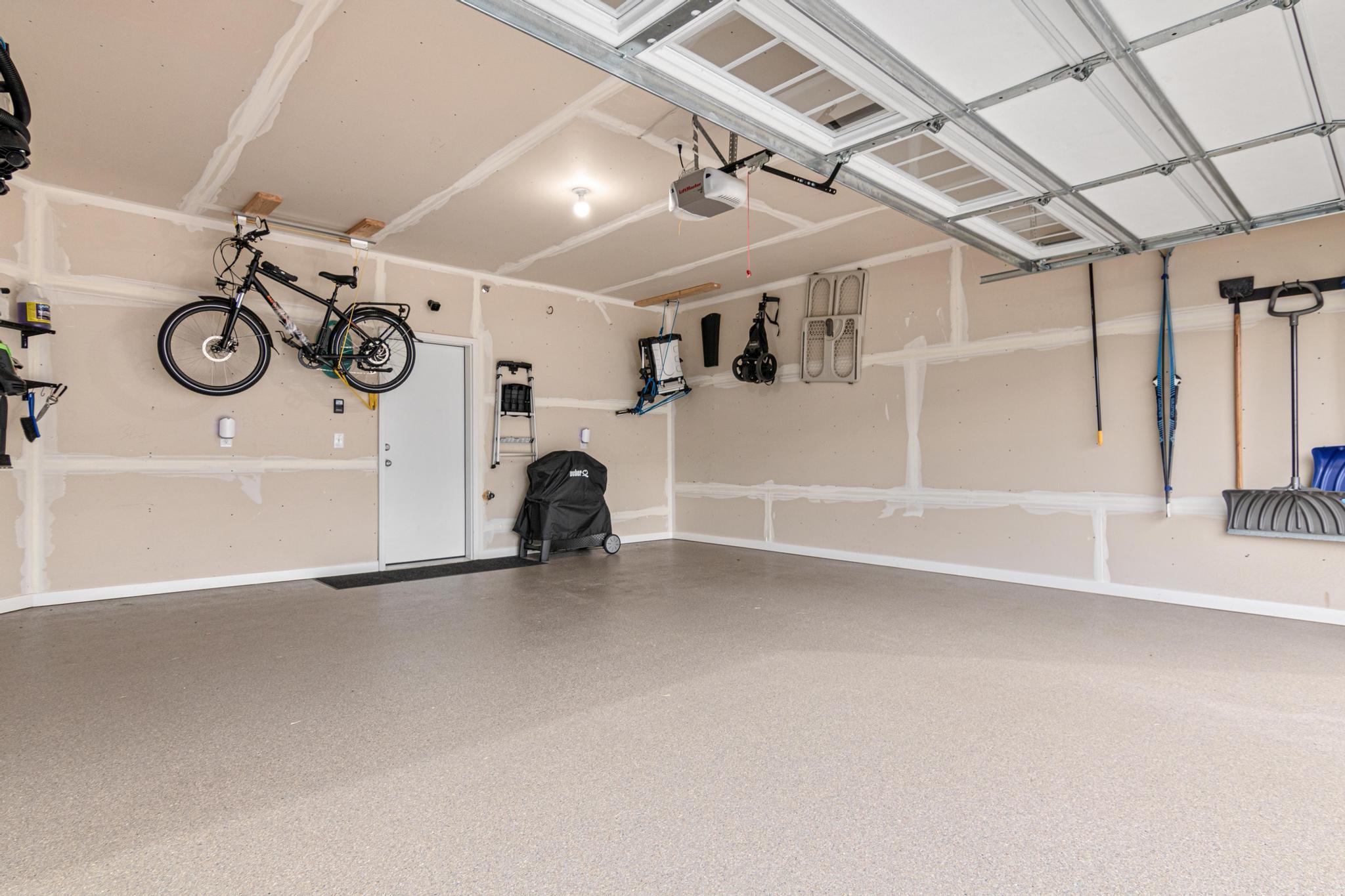 Spacious two-car garage featuring a durable, professionally finished epoxy floor. This clean and well-maintained space offers ample room for vehicles and organized storage, adding both value and functionality to this modern home.