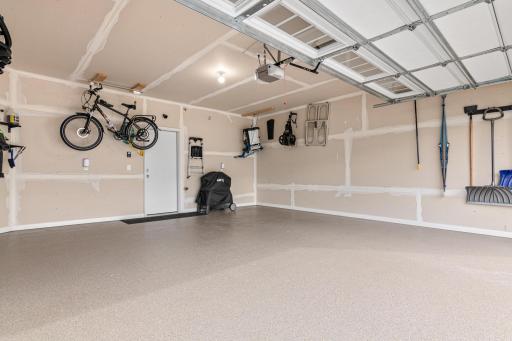 Spacious two-car garage featuring a durable, professionally finished epoxy floor. This clean and well-maintained space offers ample room for vehicles and organized storage, adding both value and functionality to this modern home.