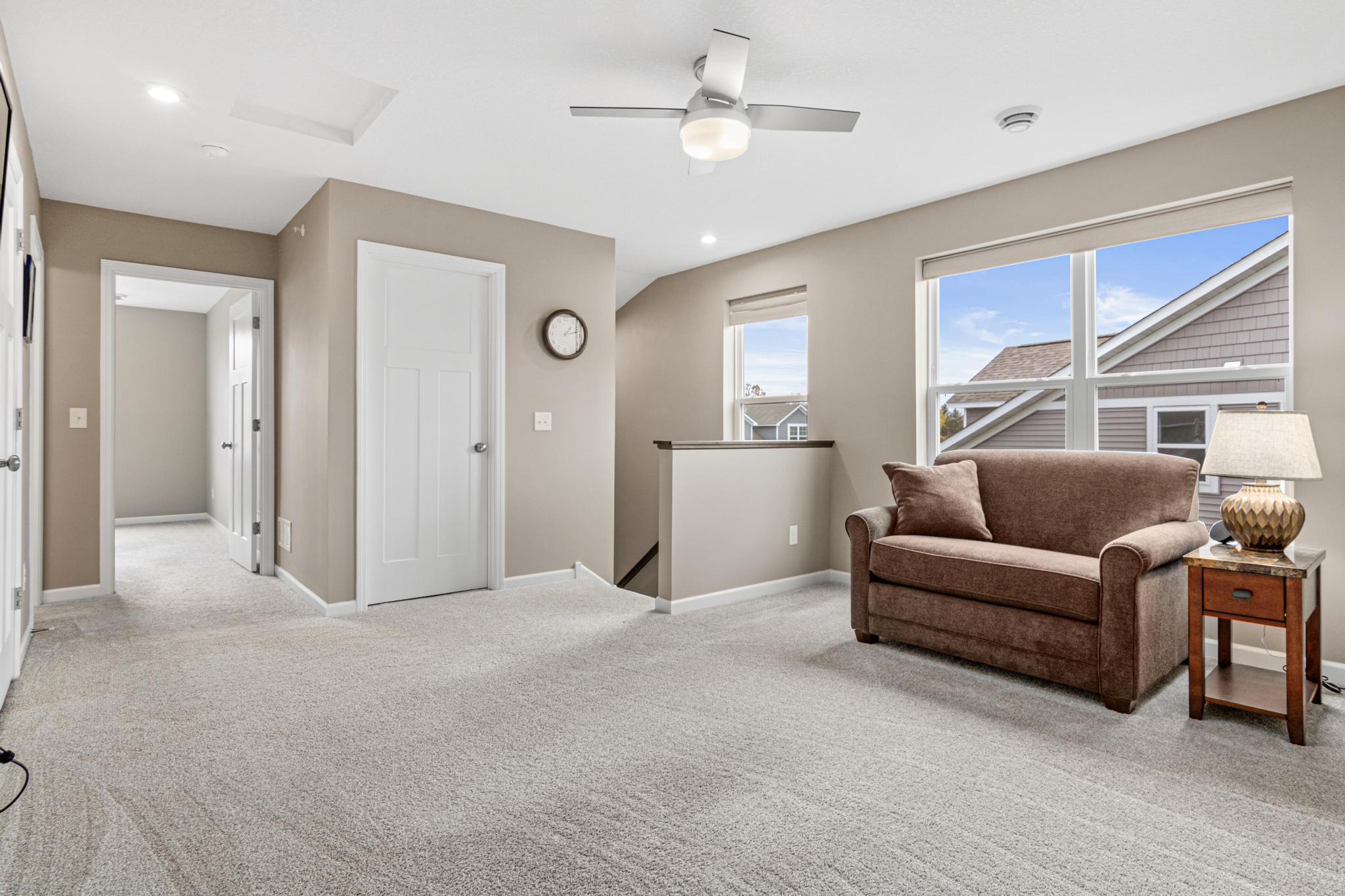 Expansive upper level showing the spacious loft, guest bedroom, and full bath. Large windows provide ample light, while the layout offers a private guest wing and extra storage. A perfect secondary living zone or quiet retreat!