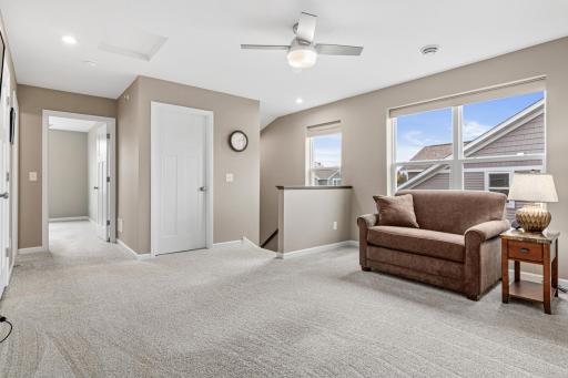 Expansive upper level showing the spacious loft, guest bedroom, and full bath. Large windows provide ample light, while the layout offers a private guest wing and extra storage. A perfect secondary living zone or quiet retreat!