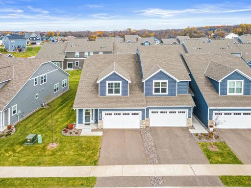 Aerial view of this premium end-unit townhome showcasing its prime location and expansive green space. Enjoy the privacy of an end unit in a quiet, modern community. Highlights the spacious side yard and professional landscaping.