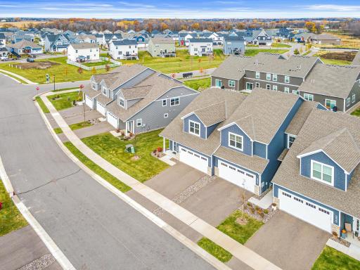 Sweeping aerial view of the quiet, master-planned community. Highlights the pristine landscaping, modern architectural design, and mature trees. A prime location offering a serene neighborhood setting while remaining close to all your local needs.