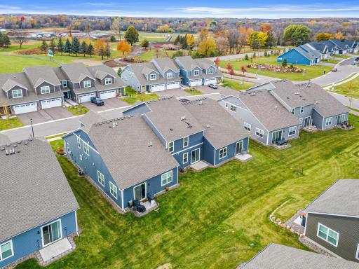 Photo from Fall 2025 showing the typical lush lawn and manicured landscaping. The premium end-unit location offers expansive green space and exceptional curb appeal, highlighting the meticulous care of this townhome community.