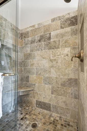 The spa like tiled, walk in shower with seat an shampoo shelf.