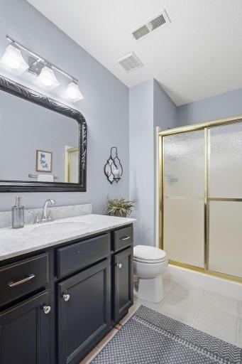 An updated lower level bath with new flooring, vanity and lighting.