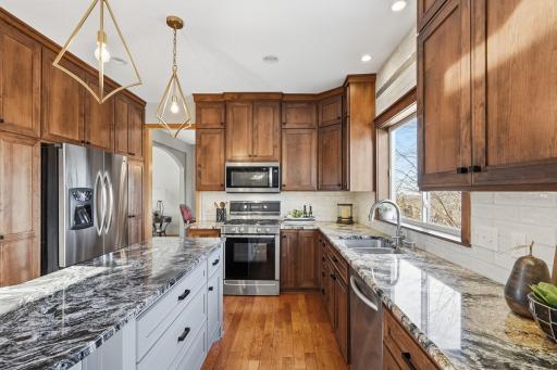Updated and on trend cabinets, granite countertops, tiled backsplash and stainless steel appliances create a beautiful space to prep meals.