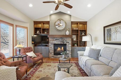 The renovated fireplace elevates the living room space with built in cabinets for decor and storage.
