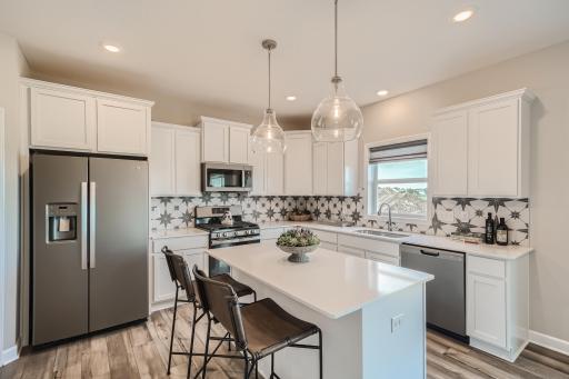 Photo is of the model. Modern and functional, this kitchen is sure to impress. This spacious room includes Quartz countertops, stainless steel appliances, a gas cooktop and a walk-in pantry.