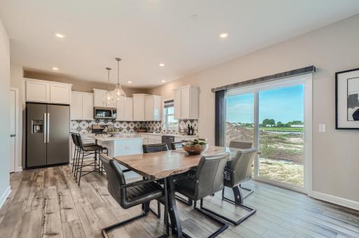 Photo is of the model. Open and naturally bright, the home's dining room is the perfect place to gather for a meal!
