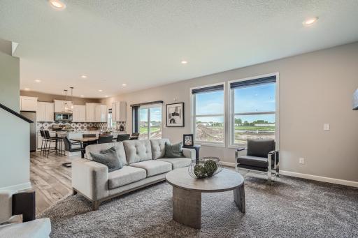 Photo is of the model. The main level seamlessly transitions from room to room while maintaining an open-concept layout throughout.