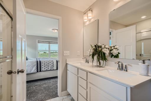 Photo is of the model. Primary private bath with double-vanity and a separate shower.