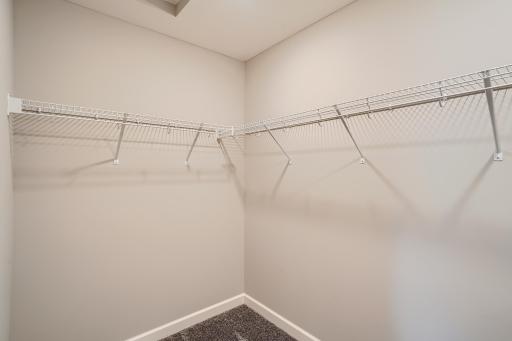 Photo is of the model. Spacious primary bedroom walk-in closet.
