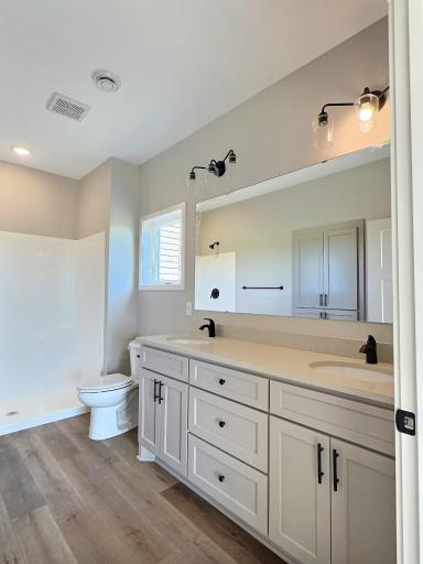 The walk in shower, double sinks and custom cabinets in the primary bathroom.