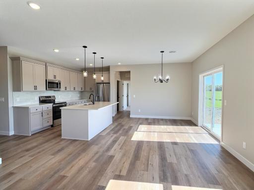The open and flowing design of this area is ideal for patio home living. The kitchen, featuring a center island, seamlessly connects to the dining and living rooms.