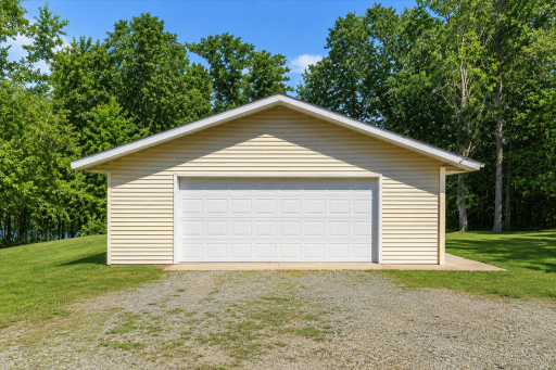Detached 2-stall garage provides excellent storage for lake toys, vehicles, tools, and outdoor gear at this 2.4-acre Dogfish Lake retreat.