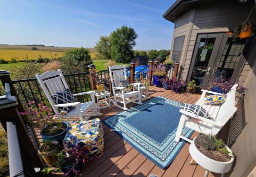 Composite deck overlooks backyard patio, with stairway to patio. Entrance door into dining nook area of the kitchen, plus another set of stairs to outdoor kitchen area.