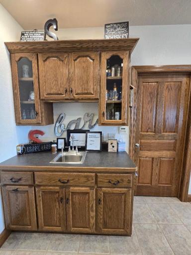Includes sink, storage cabinet for glasses & more. (Door to storage room)