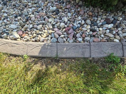 Close up view of concrete edging that borders the extensive landscaping.