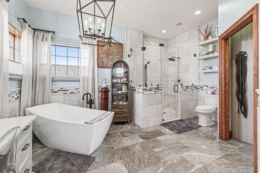 Primary bath has gorgeous marble flooring with infloor heat. Custom made cabinets from Architectural Millwork Ltdl, and an awesome soaker tub