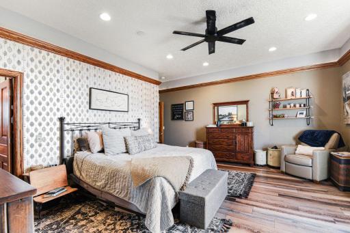 Primary bedroom with recessed lighting, ceiling fan, tray ceiling, and LVP flooring