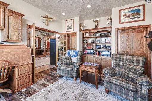 Main floor office with french doors, built in bookshelf and 2 closet doors