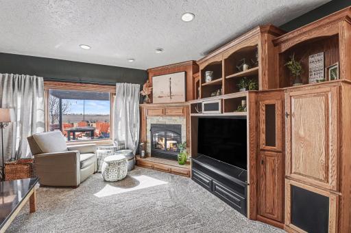 Basement family room has an oak entertainment center with an attractive corner gas fireplace with stone accents.