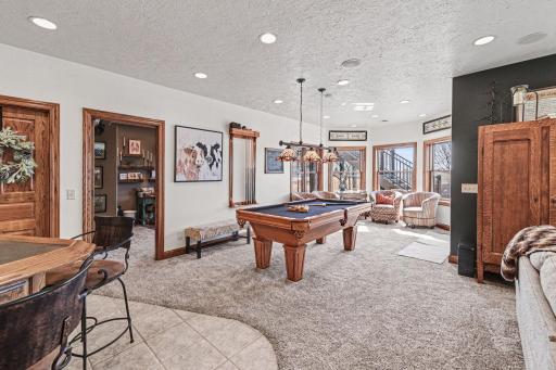 Pool table (can stay with the house) & sitting area, patio doors to southern aggregate patio. Door to craft room/bedroom & storage room.