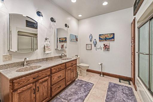 Basement full bath with tile flooring, vanity with double sinks