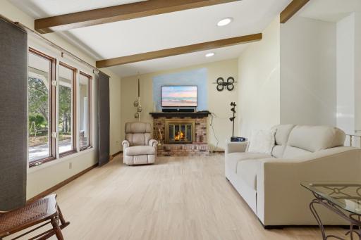 Bright living room with vaulted ceiling, Skylights and wood burning fireplace with new LVP flooring