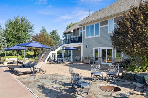 Backyard patio area with the deck. Has a walkout basement along with stairs to come down from the main level deck. Multiple areas for hosting and people gathering in the warm weathered days.