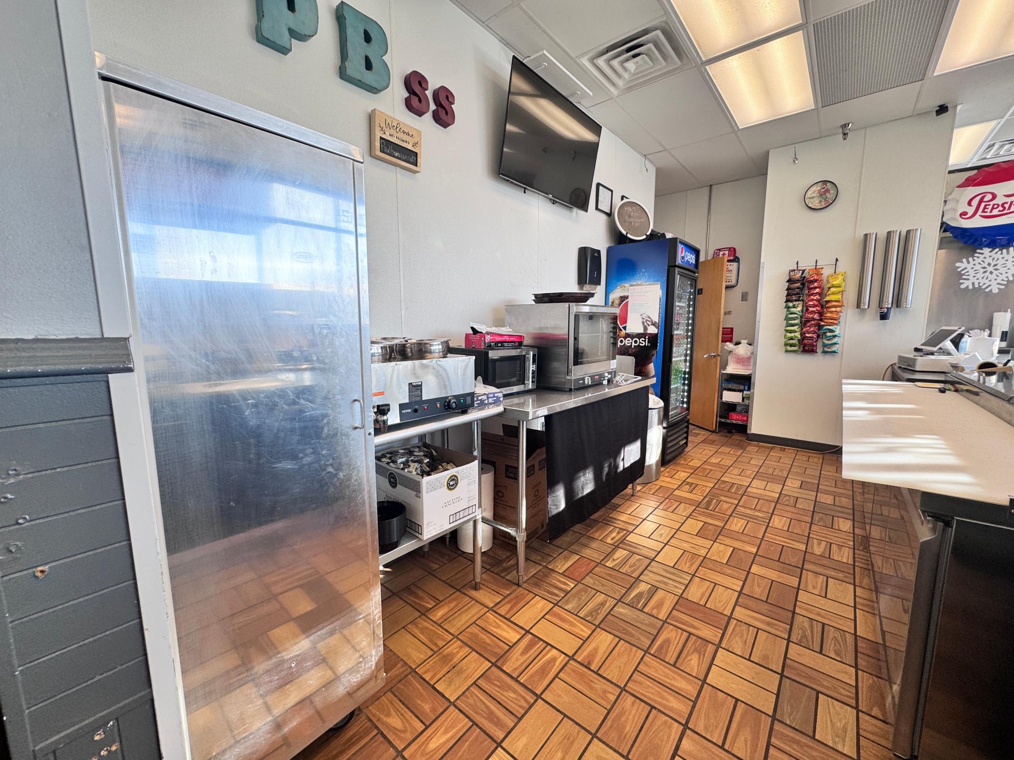 The prep area is set up for a few employees to efficiently create customer orders. It includes a Bread Rack, 4 well warmer, Toaster oven, Coffee maker, Prep station and POS located at the end
